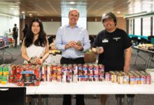 Western Sydney University provides a food pantry on campus for students struggling to afford food. Vice-chancellor Professor George Williams (centre) is pictured with Student Community Program Coordinator Ms Miranda Zhang (left) and student Richard Xu. Photo credit: Wendy Chung